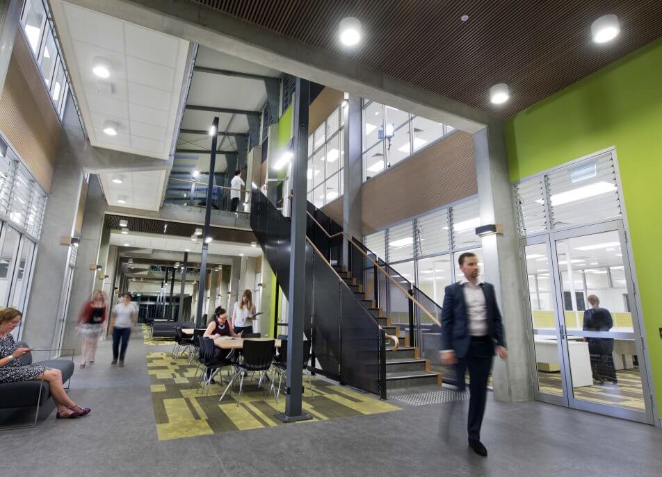 Staff in business wear and lab coats sharing a communal area of an office space