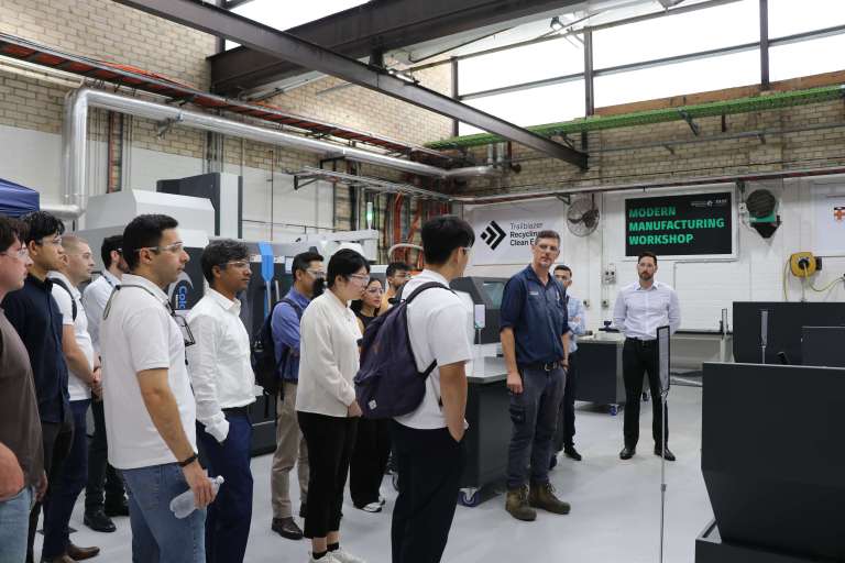 A technical officer explainging to a group of students how machinery in the modern manufacturing facility works.