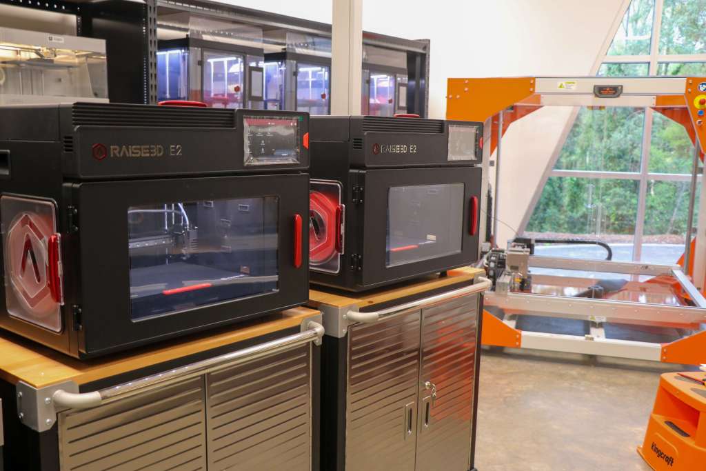An image showing two small and one large 3D printers.